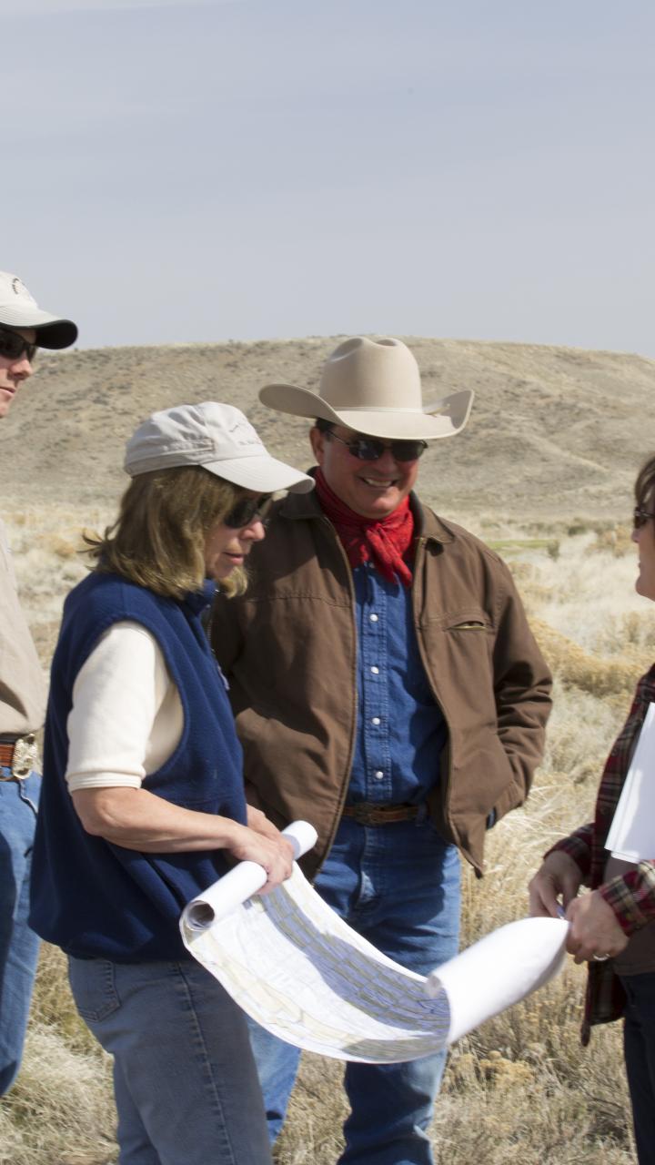 Members of the Heguy family ranch alongside USFWS and Bureau of Land Management staff reviewing progress on a habitat restoration project in Nevada.